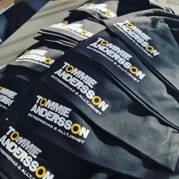 Svarta t-shirts med transfertryck i vitt och gult för Tommie Andersson Entreprenad & Alltjänst